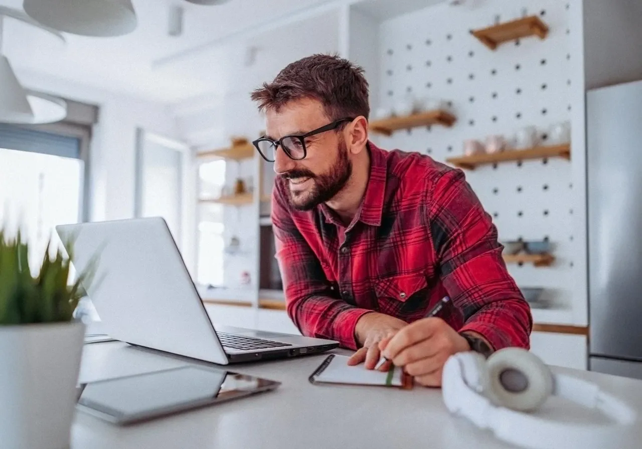 Man in red plaid at his working from home desk.